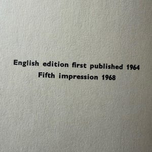 Puede incluir: Primer plano de una superficie de papel texturizado blanquecino con texto negro. El texto dice: "English edition first published 1964 Fifth impression 1968".