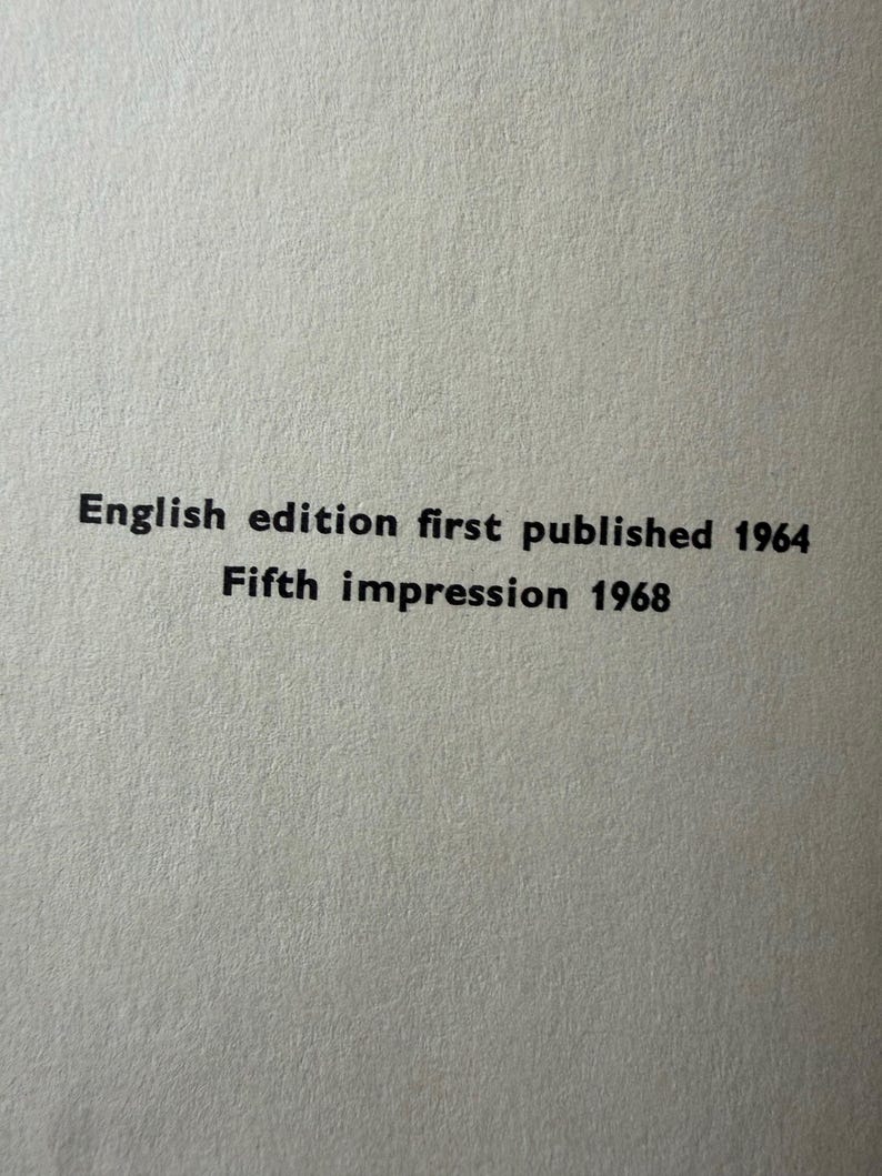 Puede incluir: Primer plano de una superficie de papel texturizado blanquecino con texto negro. El texto dice: "English edition first published 1964 Fifth impression 1968".