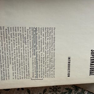 Puede incluir: Una taza de cer&aacute;mica blanca con un asa negra y el texto "But First, Coffee" en negrita negra. La taza se encuentra sobre un fondo borroso, sugiriendo un ambiente acogedor.