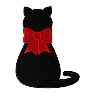Puede incluir: Silueta de gato negro con un gran lazo rojo. El gato está de espaldas al espectador.