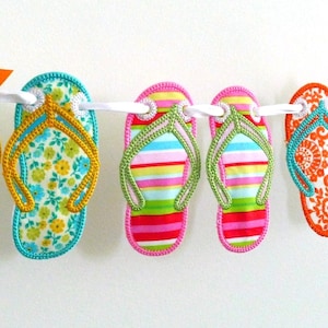 May include: A string of colorful flip-flop shaped fabric ornaments with different patterns, including floral, striped, and paisley designs.
