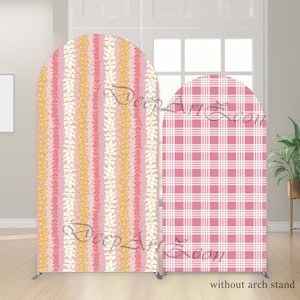 May include: Two arched backdrop covers featuring fabric prints. The taller cover displays vertical stripes of yellow and pink floral lei patterns on a light pink background. The shorter cover features a pink and white checkered plaid pattern.