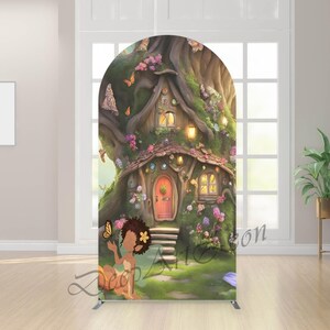 May include: A whimsical backdrop featuring a fairy house nestled within a tree, adorned with flowers and butterflies. A young fairy sits in the foreground. The backdrop has an arched top and is supported by a metal frame. The text "Deep Art Zone" is visible.