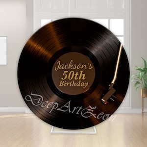 May include: A large circular backdrop featuring a black vinyl record design with a gold tone arm. The centre label is dark brown with gold text reading Jackson's 50th Birthday. The script text DeepArtEon is printed in white across the lower section.