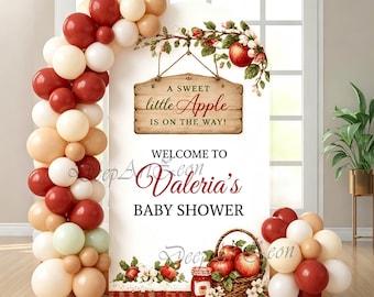 Puede incluir: Un telón de fondo arqueado blanco para un baby shower con un letrero de madera que dice A SWEET little Apple IS ON THE WAY! y WELCOME TO Valeria's BABY SHOWER. La decoración incluye una guirnalda de globos en rojo, crema y beige y motivos de manzanas.