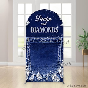 May include: A blue denim-themed backdrop with an arched top. The design features a denim pocket with sparkling diamond accents and the words "Denim and Diamonds" in silver script. The backdrop is supported by a metal stand.