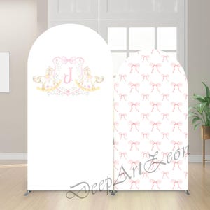May include: Two white arched backdrop panels. One panel features a pink and gold design with rocking horses and the letter "J". The other panel has a pattern of pink bows on a white background. The text "Deep Art Leon" is at the bottom.