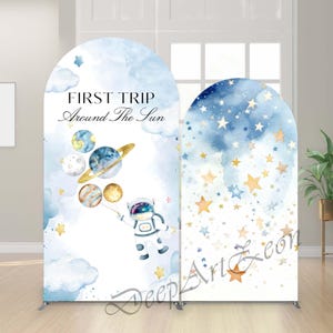 Puede incluir: Dos paneles de fondo arqueados con temática espacial. Un panel presenta un astronauta sosteniendo planetas con el texto "FIRST TRIP Around The Sun". El otro panel tiene un diseño de noche estrellada con estrellas doradas y azules.