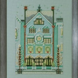 Peut inclure: Broderie au point de croix d'une maison détaillée dans un cadre en bois. La maison est principalement bleu clair et sarcelle, avec des couronnes vertes sur les fenêtres. Le toit est gris avec de la neige, et l'œuvre a un thème hivernal.