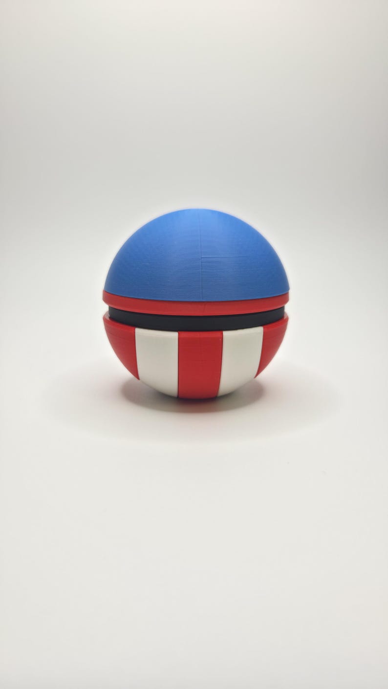 Peut inclure: Objet sph&eacute;rique avec un dessus bleu, une bande noire et un fond ray&eacute; rouge et blanc. L'objet est un &eacute;l&eacute;ment d&eacute;coratif, peut-&ecirc;tre un r&eacute;cipient ou un jouet, avec un code couleur patriotique.