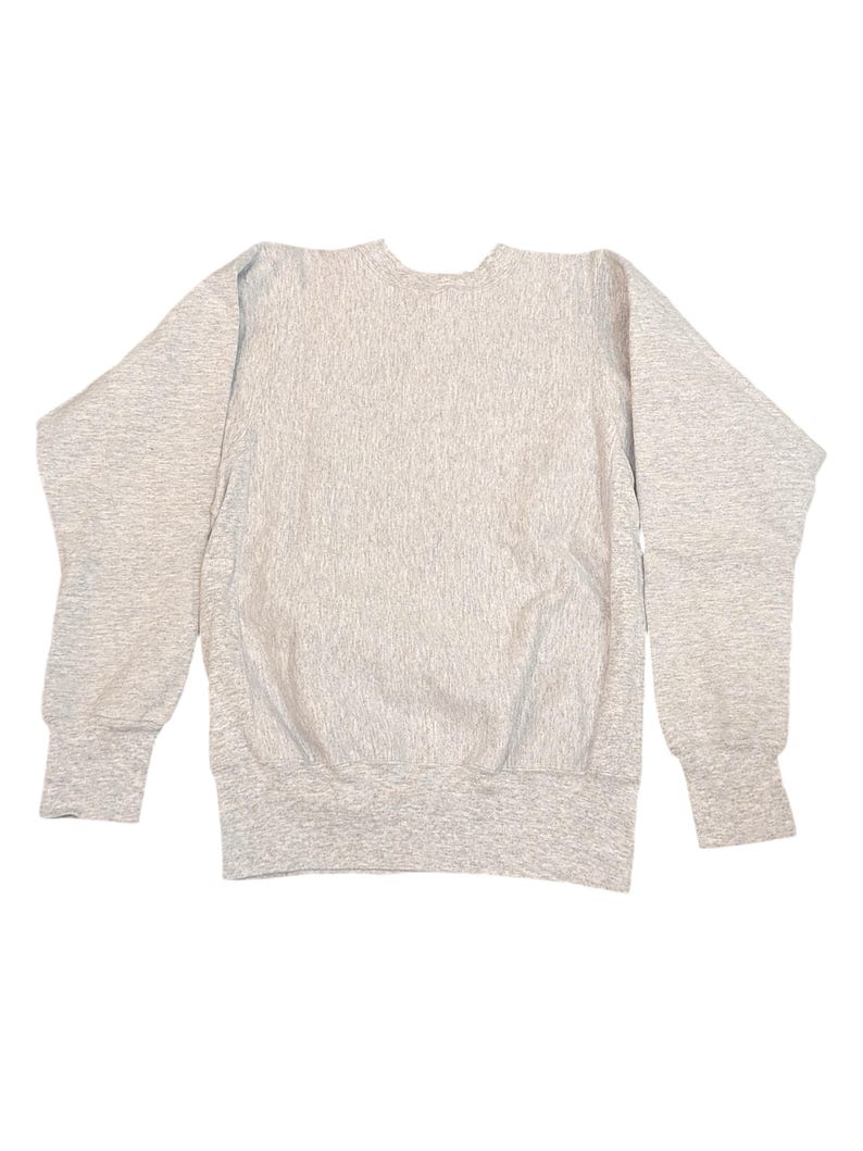 K&ouml;nnte beinhalten: Ein hellgraues Sweatshirt mit Rundhalsausschnitt und langen &Auml;rmeln. Das Sweatshirt hat gerippte B&uuml;ndchen und einen gerippten Saum. Der Stoff hat ein strukturiertes Aussehen. Das Kleidungsst&uuml;ck liegt flach auf wei&szlig;em Hintergrund.