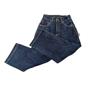 May include: Dark wash denim jeans with a classic five-pocket design. Features a button and zipper closure, belt loops, and a small red logo tag on the front pocket. The jeans have a relaxed fit and are suitable for casual wear.