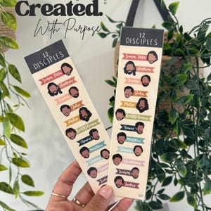 K&ouml;nnte beinhalten: Zwei beige Lesezeichen mit Illustrationen der 12 J&uuml;nger. Jedes Lesezeichen zeigt die Namen und Cartoon-Gesichter der J&uuml;nger. Der Text "Created With Purpose" und "Ephesians 2:10" befindet sich oben.