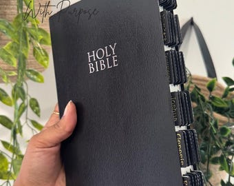 May include: Black Holy Bible with white text and labeled tabs. The cover features the words "HOLY BIBLE" and "James" in white script. The image also includes the text "Created With Purpose" and "Ephesians 2:10".