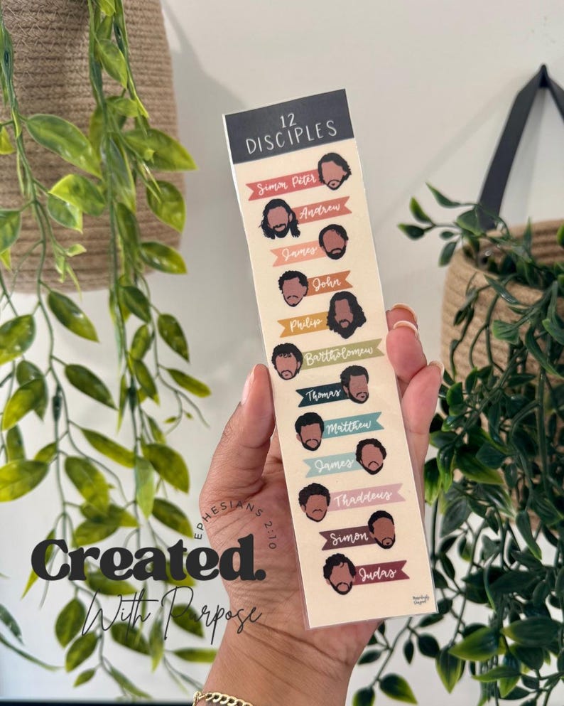 K&ouml;nnte beinhalten: Ein Lesezeichen mit Illustrationen der 12 J&uuml;nger und ihren Namen. Das Lesezeichen hat einen cremefarbenen Hintergrund mit bunten Bannern und dem Text "Created With Purpose" und "Ephesians 2:10".