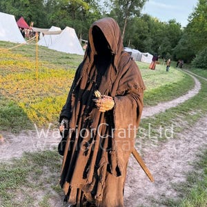 Può includere: Una tazza di ceramica bianca con manico nero e la scritta "But First, Coffee" in grassetto nero. La tazza è piena di un liquido scuro, probabilmente caffè, e poggia su una superficie chiara.