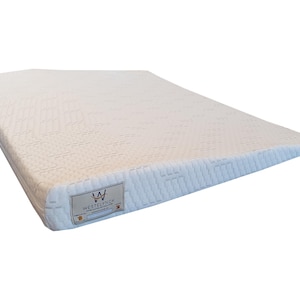 Peut inclure: Un matelas blanc avec une surface texturée et une forme rectangulaire. Le matelas a une légère inclinaison d'un côté. Une étiquette avec le texte "WESTELYNCK" est visible sur le côté.