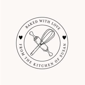 May include: Black and white illustration of a rolling pin and whisk crossed over each other inside a circle with the text "Baked with Love from the Kitchen of Susan".