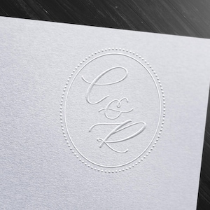 May include: A white card with a circle design featuring the letters "C & R" in a cursive font.