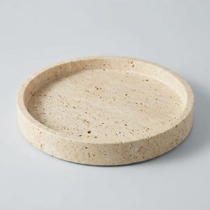 Angled view of travertine tray showing raised rim and honed natural stone finish