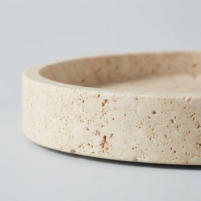 Close-up detail of travertine tray rim showing natural fossil pitting