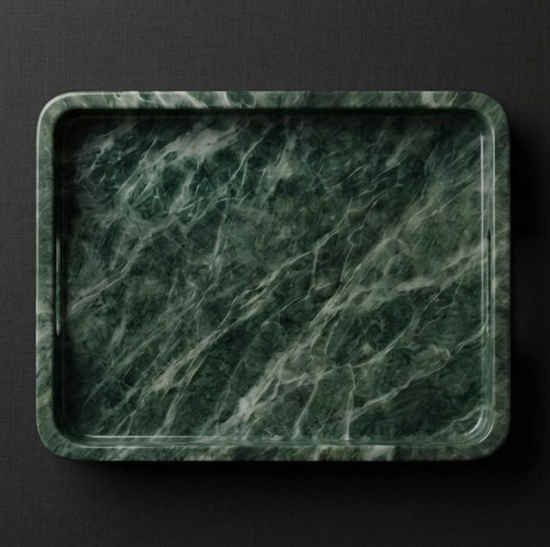 May include: Rectangular green marble tray with rounded corners. The tray features a natural veining pattern in shades of white and green. The tray is designed for serving or display.