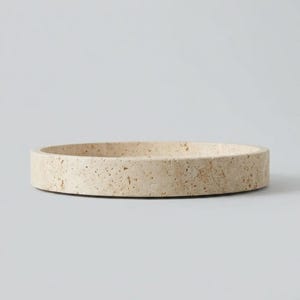 Side profile of round travertine tray on white background
