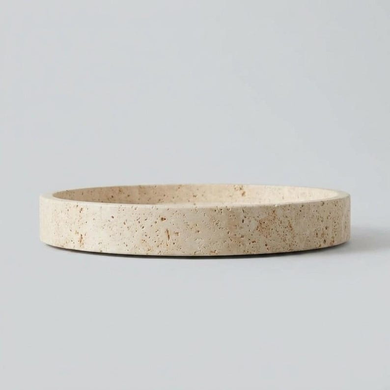 Side profile of round travertine tray on white background