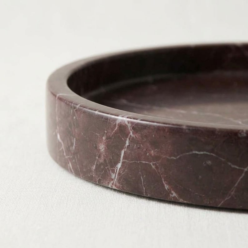 Close-up of rosso levanto marble tray rim edge showing natural stone texture