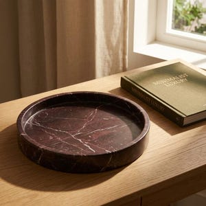 Rosso levanto marble catchall tray styled on wood console table beside a book