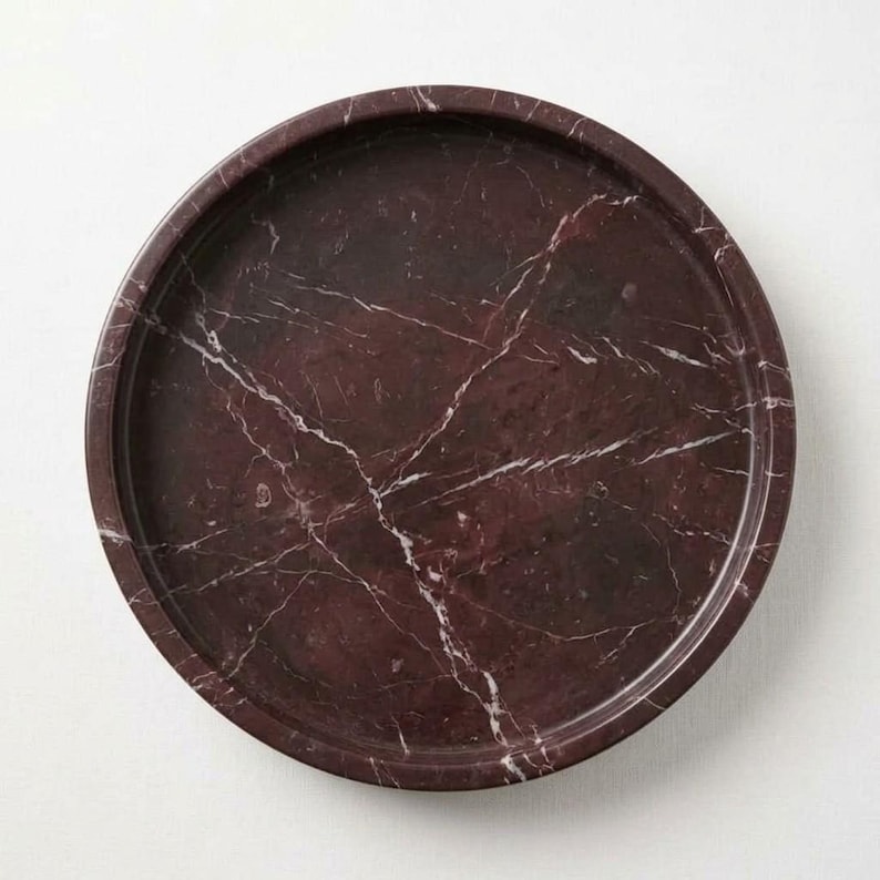 Overhead flat lay of round rosso levanto marble tray showing full veining pattern