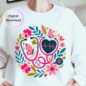 May include: White sweatshirt featuring a pink stethoscope design with a heart-shaped chest piece displaying a heartbeat. The design includes pink flowers, butterflies, and leaves. The words "Digital Download" are in a circle in the upper left.