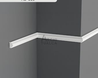 Könnte beinhalten: Weiße Zierleiste an einer grauen Wand montiert. Die Leiste ist in einer Ecke abgewinkelt, wodurch ihr Design zur Geltung kommt. Der Text "AD-025" befindet sich in einem weißen Rechteck oben. Das Logo "ARCHI TUALCA" ist sichtbar.