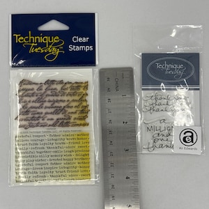 Pode incluir: Carimbos transparentes da Technique Tuesday, em embalagens de plástico. Uma embalagem tem texto manuscrito, a outra tem as palavras "Thank You" e "a million and one thank you". Uma régua está incluída.