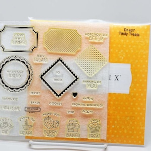 May include: Clear acrylic stamps with various phrases and images, including "Yummy in my tummy," "My special friend," and "Tasty Treats." The set includes stamps of a pie, cupcake, and strawberries. A yellow and white patterned package is visible.