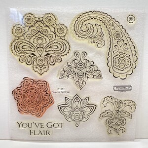 May include: A clear sheet of cling stamps with intricate black and white designs. The stamps feature paisley patterns, floral motifs, and geometric shapes. The text "You've Got Flair" is printed on the sheet.