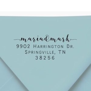 May include: A stack of light blue envelopes with printed black text. The text includes a name, street address, city, state, and zip code. The envelopes are a soft pastel color.