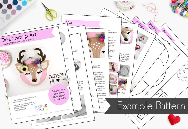 May include: A pink and brown felt deer head hoop art craft pattern with instructions. The pattern includes a deer head, antlers, flowers, and a button. The pattern is titled "Deer Hoop Art" and "Create your very own Deer Head Hoop Art x".