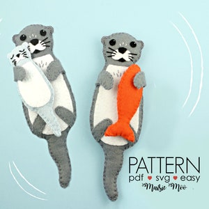 May include: Two felt otter plushies, one holding a fish and the other holding a smaller otter plushie. The otters are gray with white bellies and black eyes. The fish is orange. The background is light blue with white wavy lines.