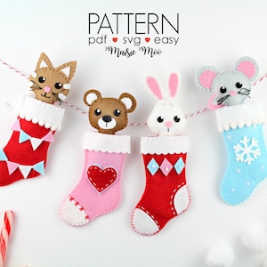May include: A felt garland featuring four Christmas stockings, each with a different animal head: a cat, a bear, a bunny, and a mouse. The stockings are red, pink, and blue, with white trim and various decorative elements. The text "PATTERN" is at the top.