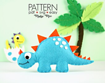 May include: A turquoise felt dinosaur with orange spikes and white spots, beside a yellow dinosaur hatching from an egg. The image includes the text "PATTERN pdf svg easy Maisie Moo". A felt palm tree is in the background.