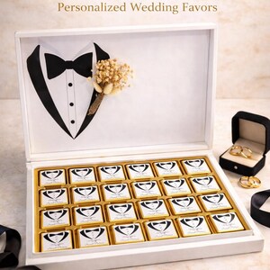 Op de afbeelding: Een witte doos chocolade voor een bruidegom, met een smoking-afbeelding en de tekst "Groom Chocolate Box, Personalized Wedding Favors". De doos bevat chocolaatjes met een smoking-ontwerp. Een klein boeket en trouwringen zijn ook zichtbaar.