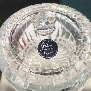 Puede incluir: Tarro de cristal transparente con tapa, con un patr&oacute;n tallado en diamante. La tapa tiene un pomo facetado. Una etiqueta en el tarro dice "Thomas James Crystal, Mouth Blown, Czech Republic, Hand Cut."