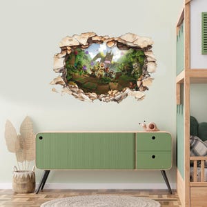Puede incluir: Un vinilo decorativo que presenta un efecto 3D de un agujero en una pared, revelando una escena de fantasía vibrante. La escena incluye personajes, un castillo y exuberante vegetación. El vinilo está rodeado por un borde texturizado similar a la piedra.