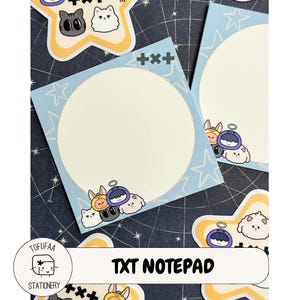 May include: A set of TXT notepads with a light blue background and star patterns. Each notepad has a large, off-white circle for writing, and is decorated with cartoon cat and bunny characters. The text "TXT NOTEPAD" is displayed.