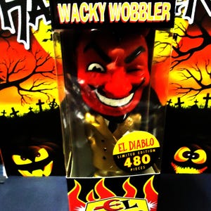 May include: A boxed "Wacky Wobbler" figure of a red devil with a winking expression. The box features the text "EL DIABLO" and "LIMITED EDITION 480 PIECES" with a Halloween-themed background.