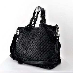 Pu&ograve; includere: Borsa tote in pelle nera intrecciata con manico superiore e tracolla rimovibile.