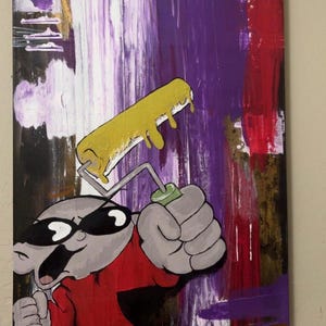 以下が含まれることがあります： 赤いシャツを着てサングラスをかけた漫画のキャラクターが、黄色い塗料が垂れているペイントローラーを持っています。背景は、紫、白、赤、金色のアクセントがついたカラフルな抽象画です。