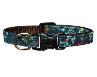 May include: A teal blue cat collar with a floral pattern and a gold metal D-ring. The collar has a black plastic buckle.