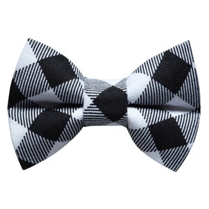 May include: A black and white checkered bow tie. The bow tie is made of a fabric with a white background and black squares.